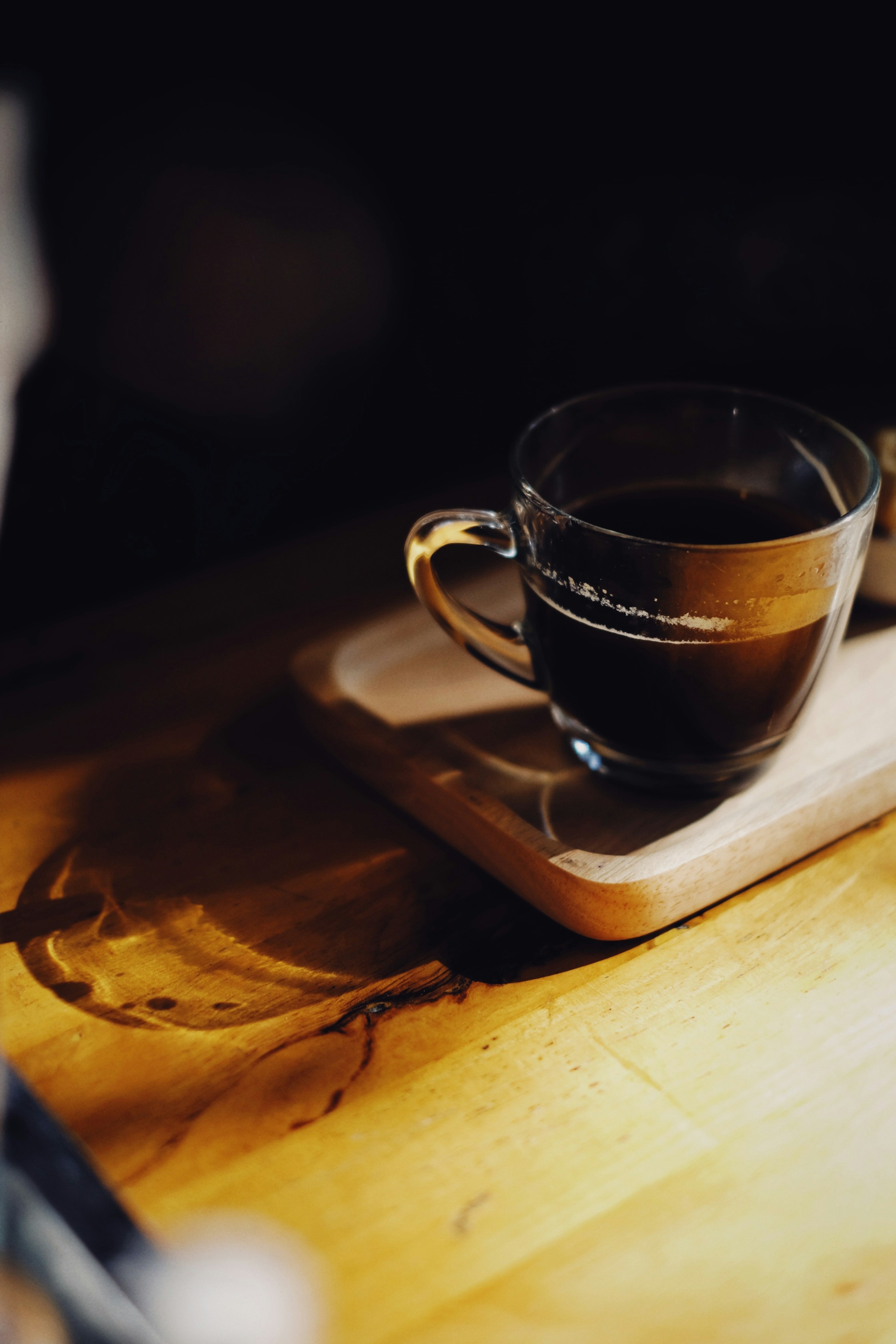 A cup of freshly brewed coffee on a wooden board